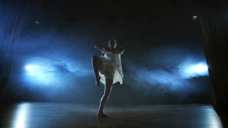 Mujer-Bailarina-De-Ballet-Moderno-Descalza-Haciendo-Giros-Y-Piruetas-Y-Pasos-De-Baile-De-Pie-En-El-Escenario-En-Humo-En-Cámara-Lenta.-Actuación-En-El-Escenario.